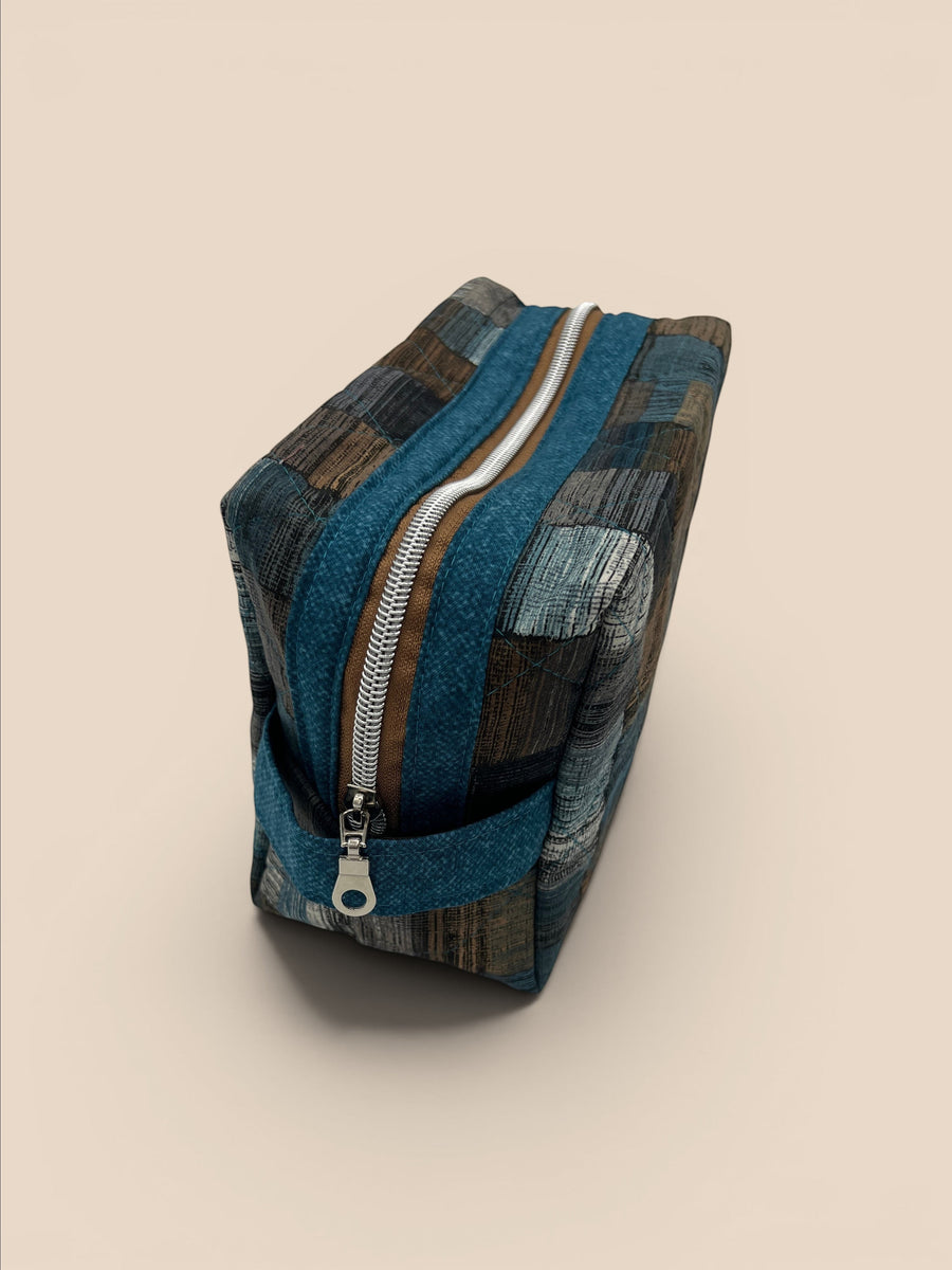 Blue and Earth Tone Patchwork Holland pouch, end view showing the boxy shape and carry handle — handmade by The Cozy Daisy