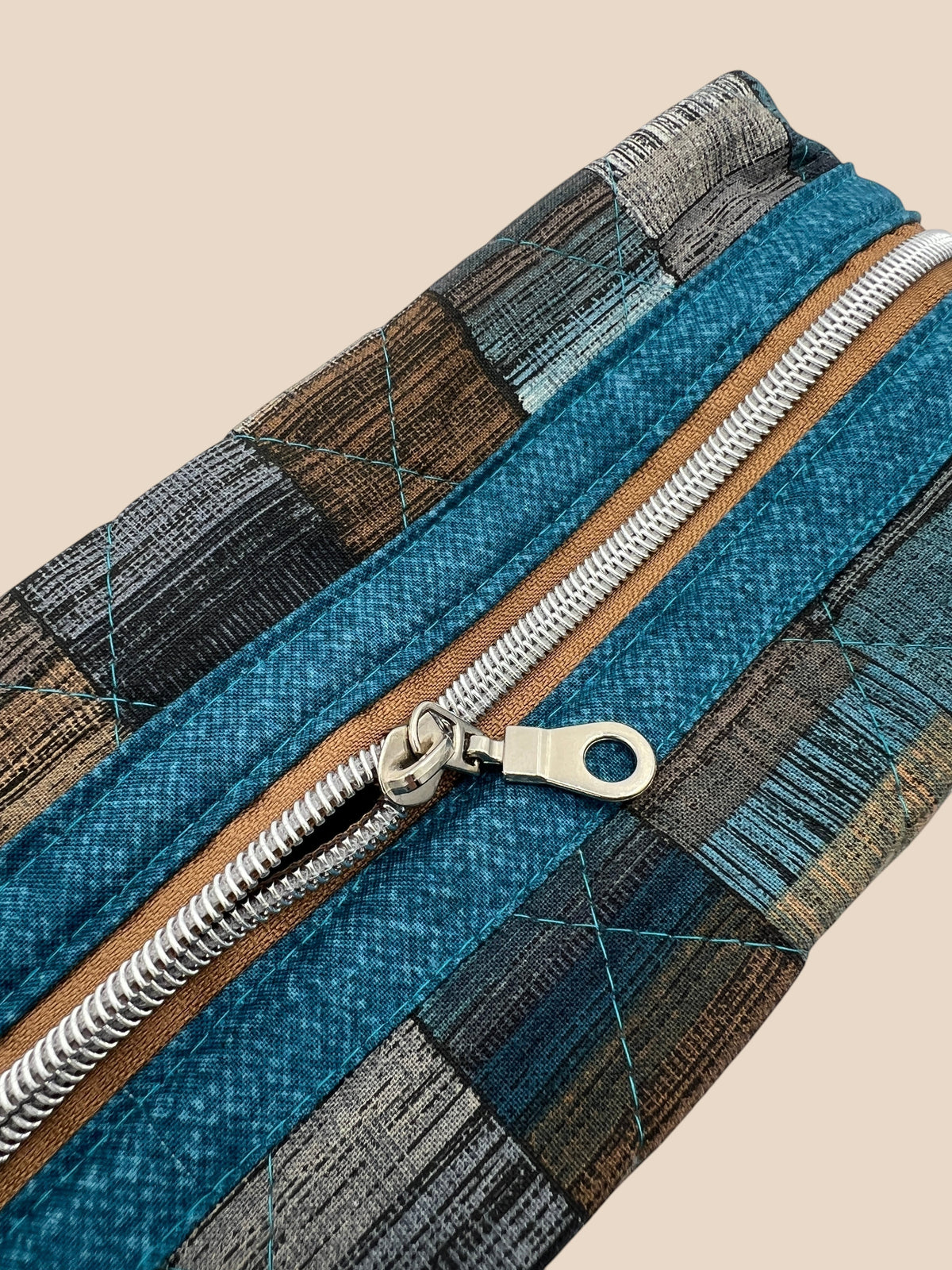 Blue and Earth Tone Patchwork Holland pouch, close-up of the copper and teal top zipper — handmade by The Cozy Daisy