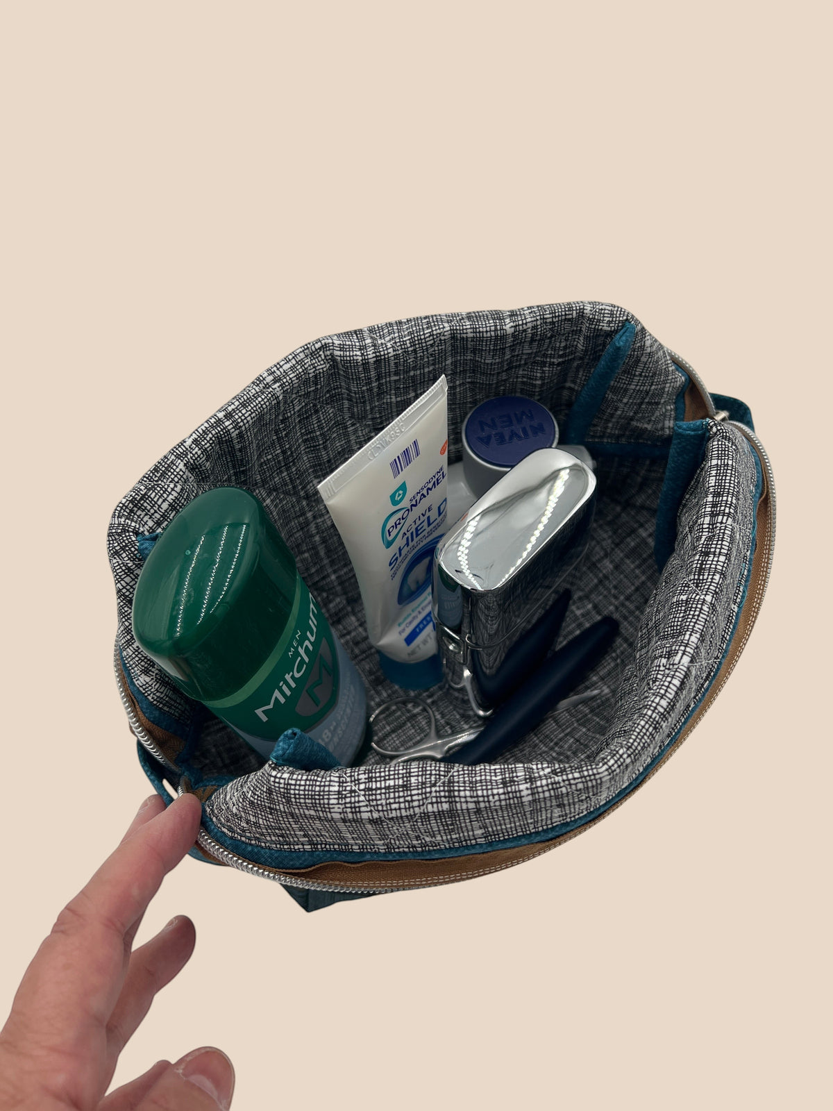 Blue and Earth Tone Patchwork Holland pouch, open and packed with toiletries to show how much it holds — handmade by The Cozy Daisy