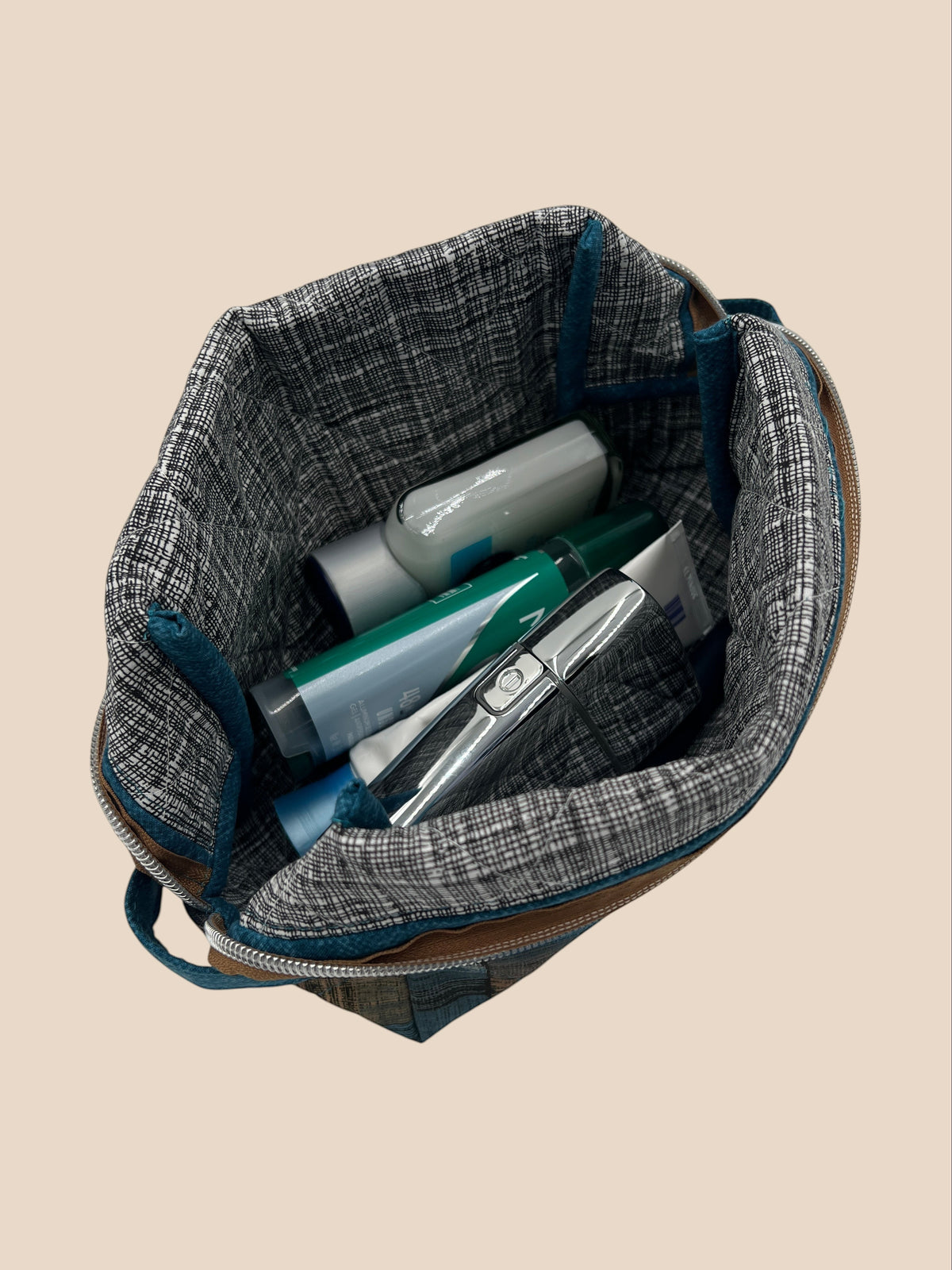 Blue and Earth Tone Patchwork Holland pouch, top-down view of the open pouch holding travel-size items — handmade by The Cozy Daisy
