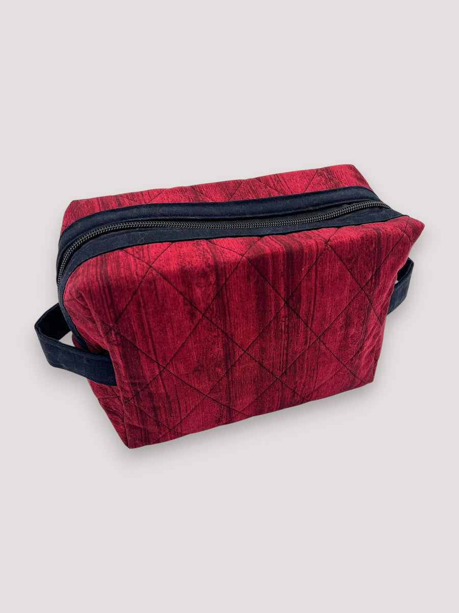 Distressed Ruby Holland pouch in deep quilted red, front three-quarter view, zipped closed — handmade by The Cozy Daisy