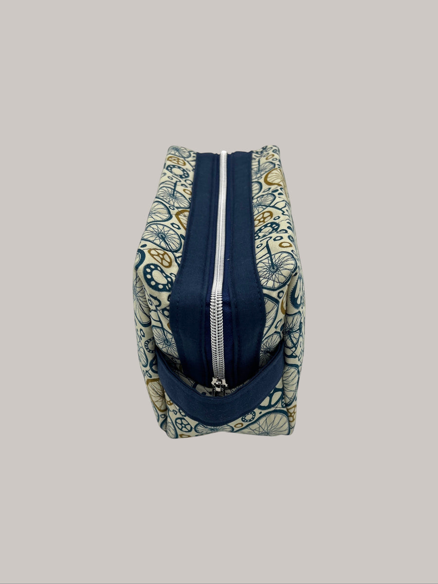 Wheels Go Round Holland pouch, end view showing the boxy shape and navy carry handle — handmade by The Cozy Daisy