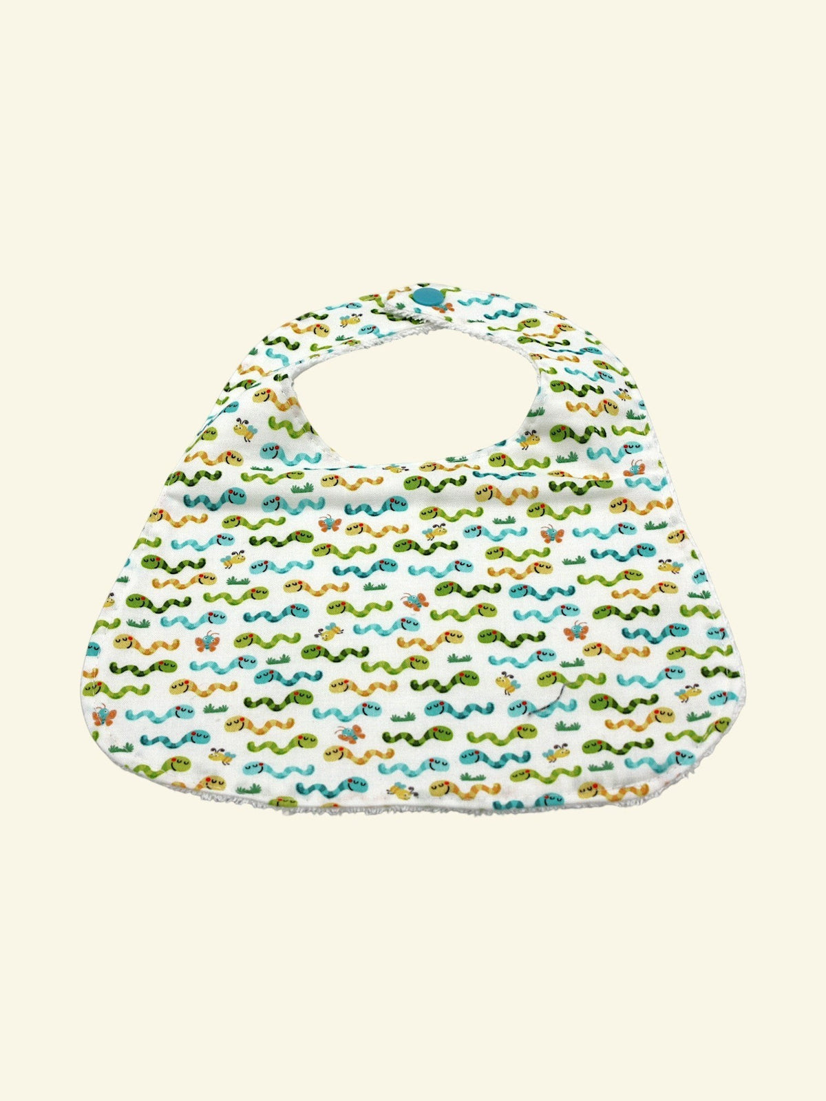 The Cozy Daisy baby bib in a white cotton fabric featuring a colorful worms print with a snap closure.