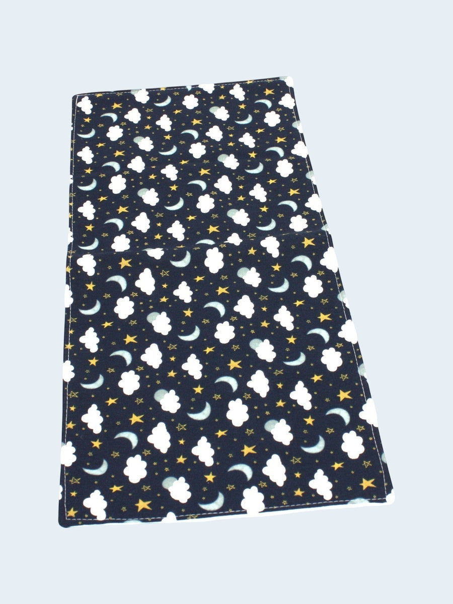 The Cozy Daisy handmade burp cloth in dark blue sky print with white clouds, yellow stars, and crescent moons.